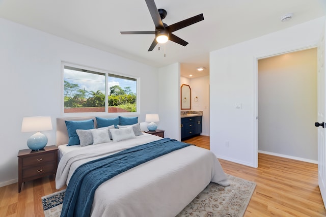 bedroom with ensuite bathroom, ceiling fan, and light hardwood / wood-style flooring