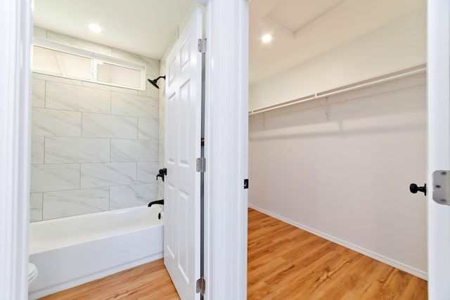 bathroom featuring hardwood / wood-style floors and tiled shower / bath