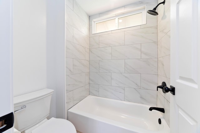 bathroom featuring tiled shower / bath combo and toilet