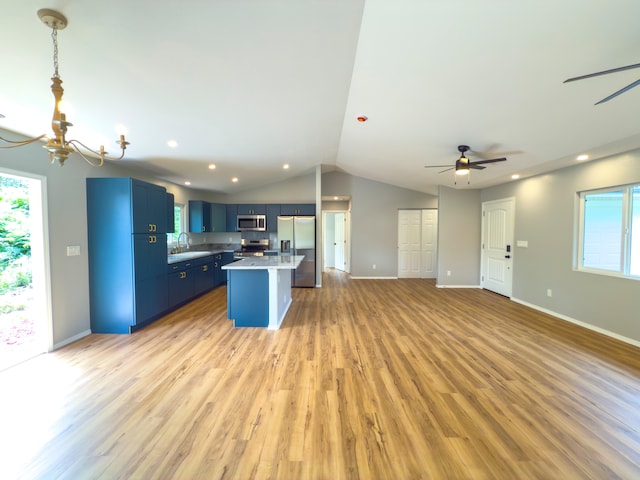 kitchen with stainless steel appliances, blue cabinets, a breakfast bar area, a kitchen island, and light wood-type flooring