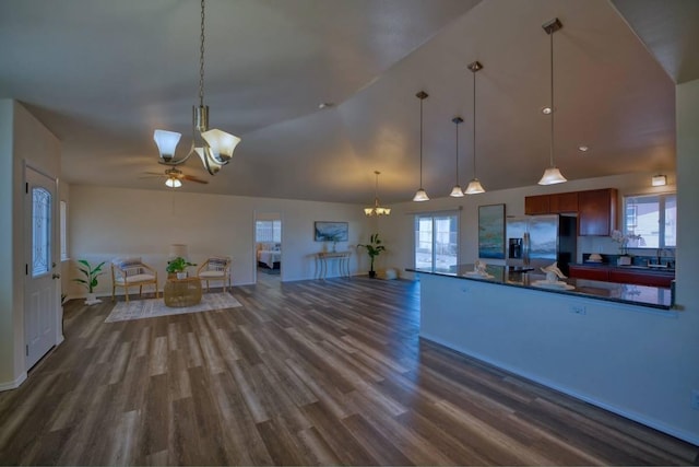 kitchen featuring stainless steel fridge, ceiling fan with notable chandelier, dark hardwood / wood-style floors, and hanging light fixtures