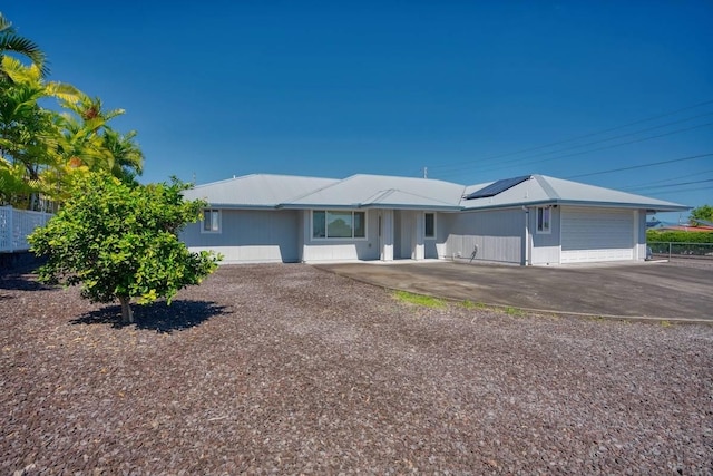 ranch-style home with solar panels and a garage