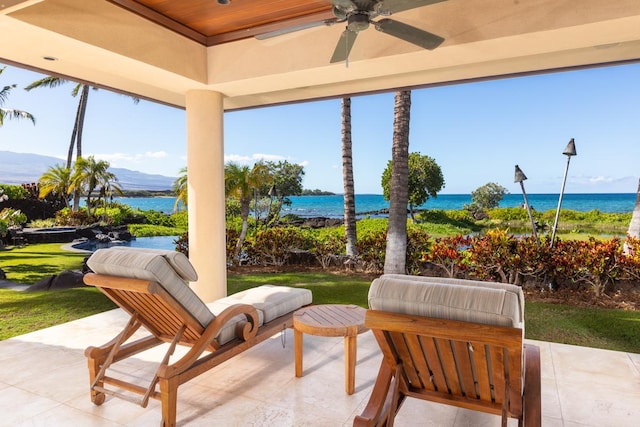 exterior space featuring ceiling fan and a water view