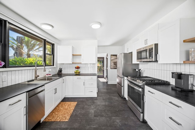 kitchen featuring white cabinets, stainless steel appliances, tasteful backsplash, and sink