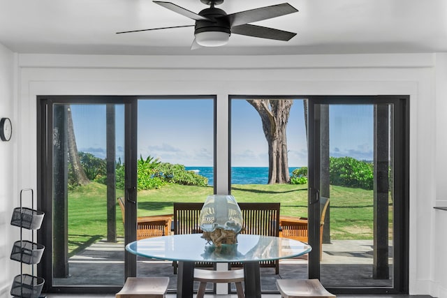 sunroom / solarium featuring a water view and ceiling fan