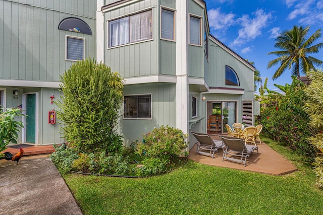 rear view of house with a patio area and a yard