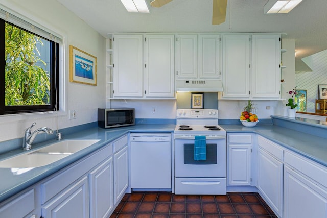 kitchen with sink, dark tile patterned floors, white appliances, white cabinets, and custom range hood