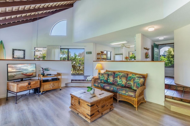 living room with lofted ceiling with beams, wooden ceiling, ceiling fan, and light hardwood / wood-style floors