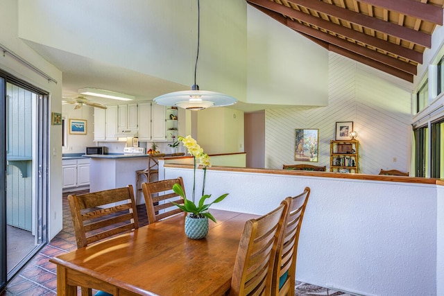 tiled dining area with beamed ceiling and high vaulted ceiling