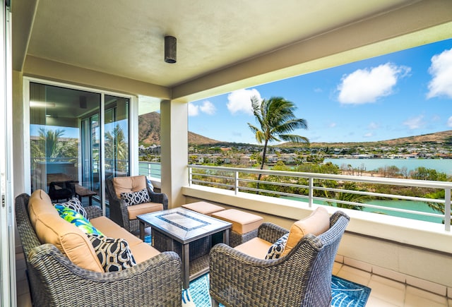 balcony with outdoor lounge area and a water view