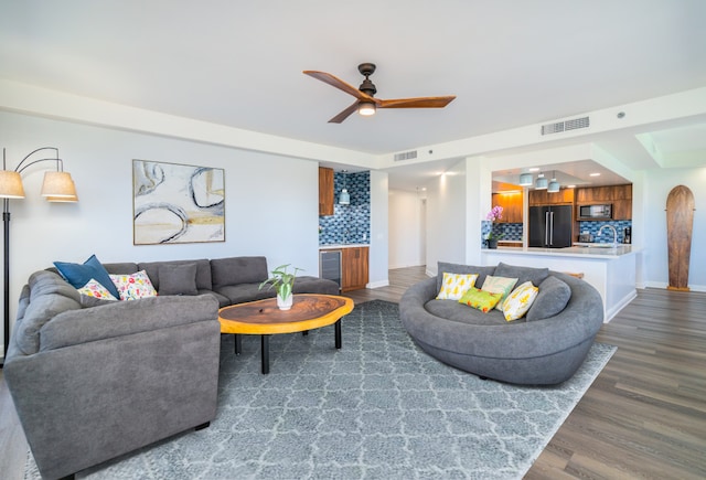 living room with dark hardwood / wood-style flooring, ceiling fan, and beverage cooler