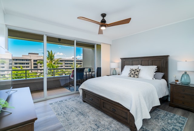 bedroom with access to exterior, hardwood / wood-style floors, and ceiling fan