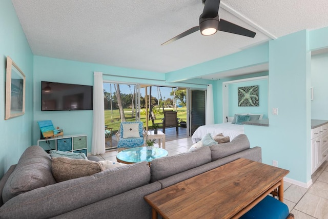 tiled living room featuring ceiling fan and a textured ceiling