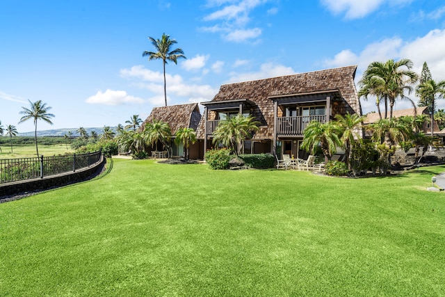 rear view of property featuring a lawn