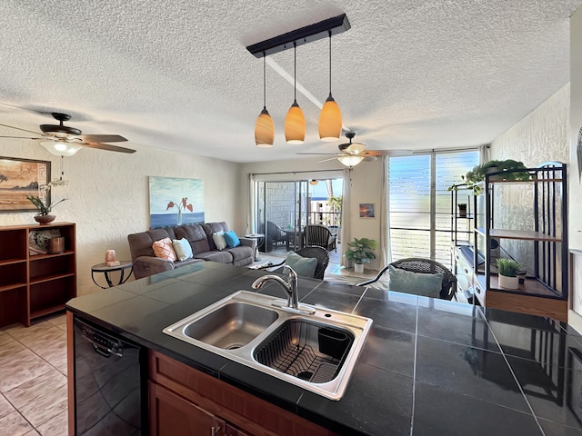 kitchen with sink, hanging light fixtures, a textured ceiling, black dishwasher, and light tile patterned flooring