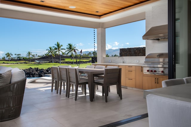 view of patio / terrace featuring a mountain view, a wet bar, area for grilling, and exterior kitchen