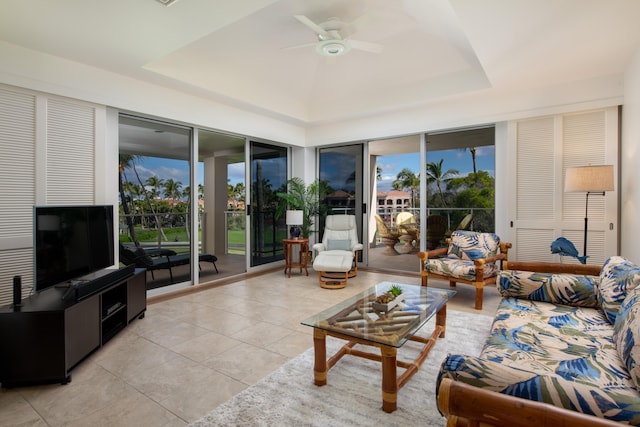 sunroom with ceiling fan and a tray ceiling