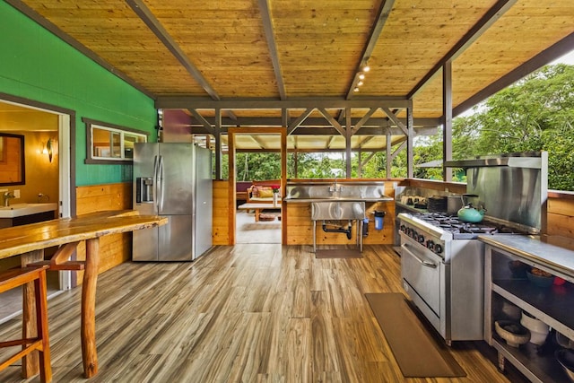 kitchen with wooden ceiling, track lighting, lofted ceiling with beams, light hardwood / wood-style flooring, and appliances with stainless steel finishes