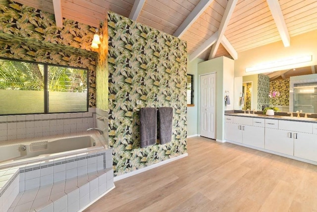 bathroom with wood ceiling, vanity, tiled tub, hardwood / wood-style flooring, and vaulted ceiling with beams