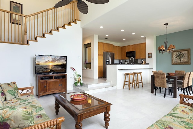 living room with sink and ceiling fan with notable chandelier