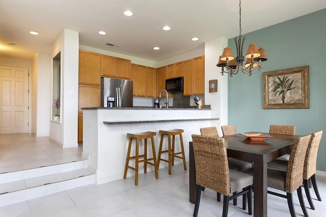 dining room with sink, light tile patterned flooring, and an inviting chandelier