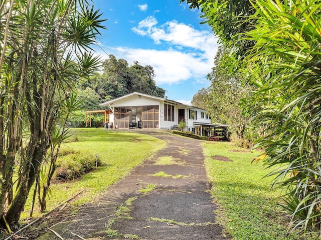 view of front of home featuring a carport, a sunroom, and a front yard