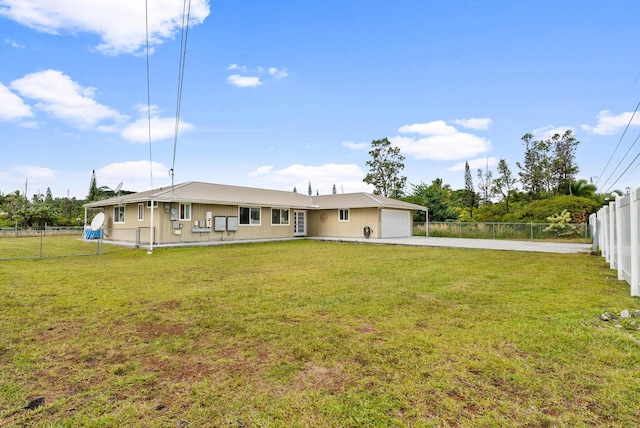 rear view of property featuring a yard and a garage