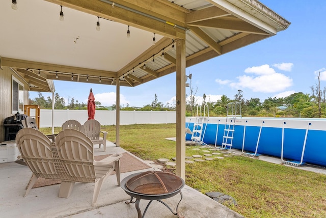 view of patio / terrace with a fenced in pool and an outdoor fire pit