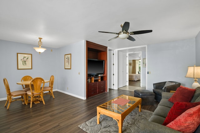 living room featuring ceiling fan and dark wood-type flooring