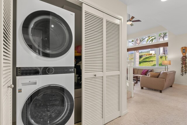 laundry area with light carpet, ceiling fan, and stacked washer / drying machine