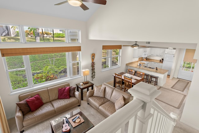 carpeted living room featuring ceiling fan and high vaulted ceiling