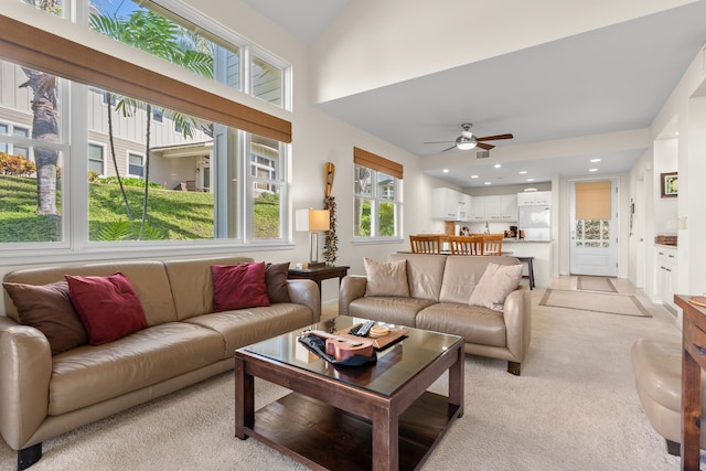 carpeted living room featuring ceiling fan and vaulted ceiling