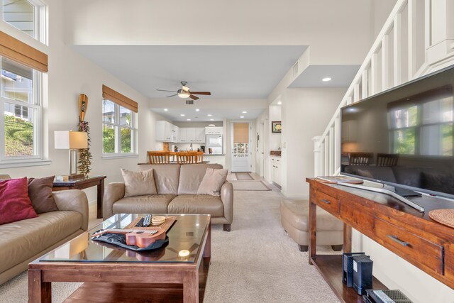 carpeted living room with ceiling fan