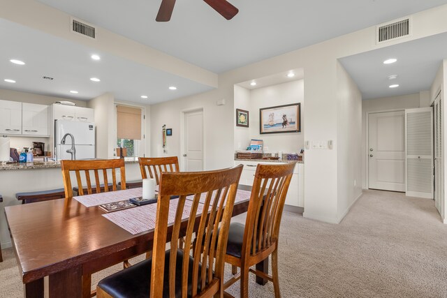 carpeted dining area featuring ceiling fan