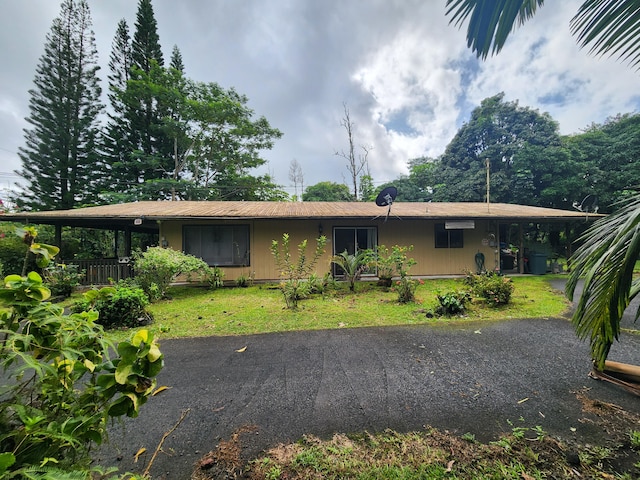 rear view of house featuring a carport and a lawn