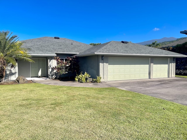 single story home with a front yard, a mountain view, and a garage