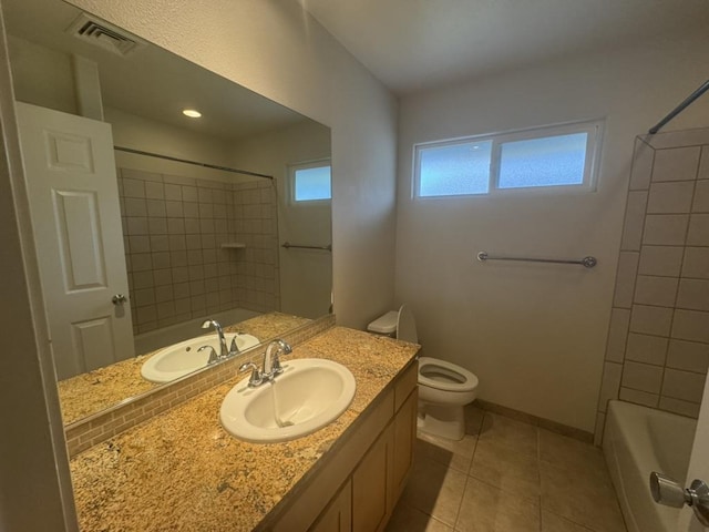 full bathroom featuring tile patterned floors, vanity, tiled shower / bath combo, and toilet