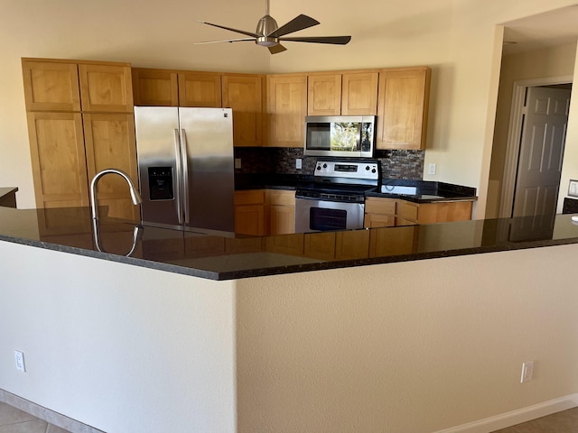 kitchen with backsplash, ceiling fan, light tile patterned floors, kitchen peninsula, and stainless steel appliances