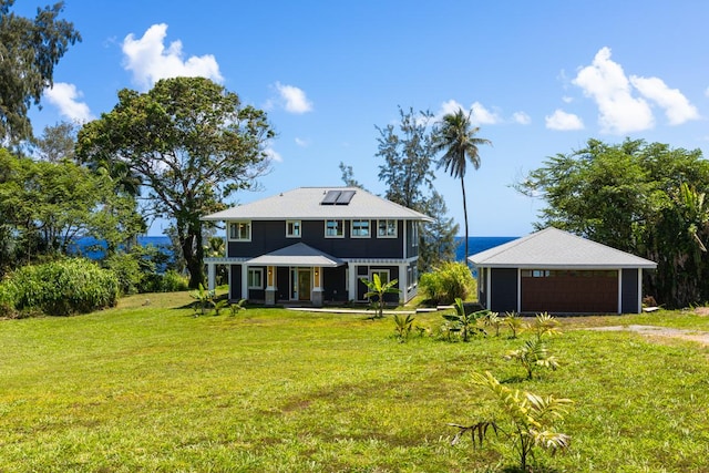 view of front of home featuring a front yard, solar panels, and covered porch