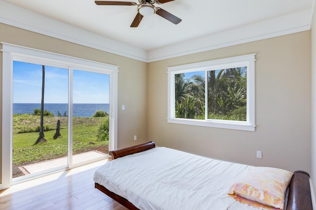 bedroom featuring access to exterior, wood-type flooring, a water view, and ceiling fan