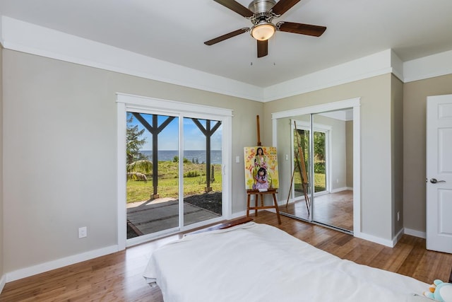 bedroom featuring hardwood / wood-style flooring, ceiling fan, access to outside, and a closet