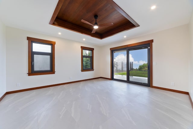 unfurnished room featuring ceiling fan, a tray ceiling, and wooden ceiling