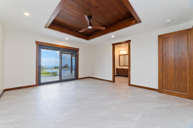 spare room featuring wooden ceiling, a tray ceiling, and ceiling fan