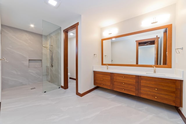 bathroom with toilet, vanity, and tiled shower