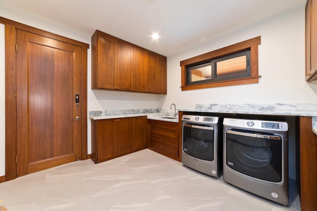 clothes washing area featuring sink, washer and dryer, and cabinets