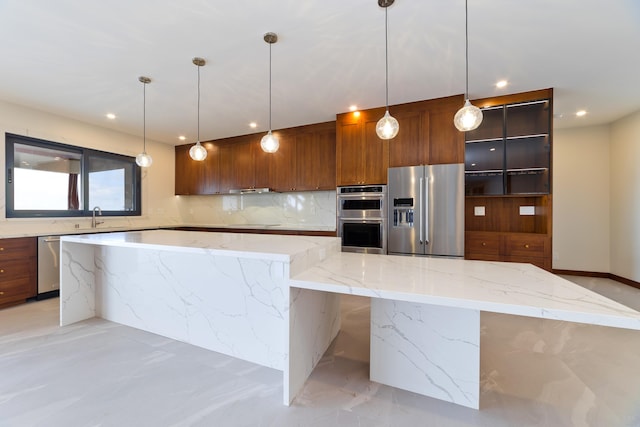 kitchen featuring light stone counters, backsplash, stainless steel appliances, and hanging light fixtures