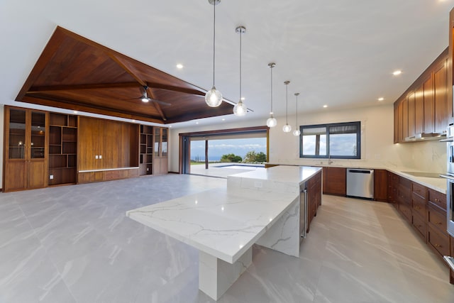 kitchen with dishwasher, a raised ceiling, hanging light fixtures, light stone countertops, and a large island