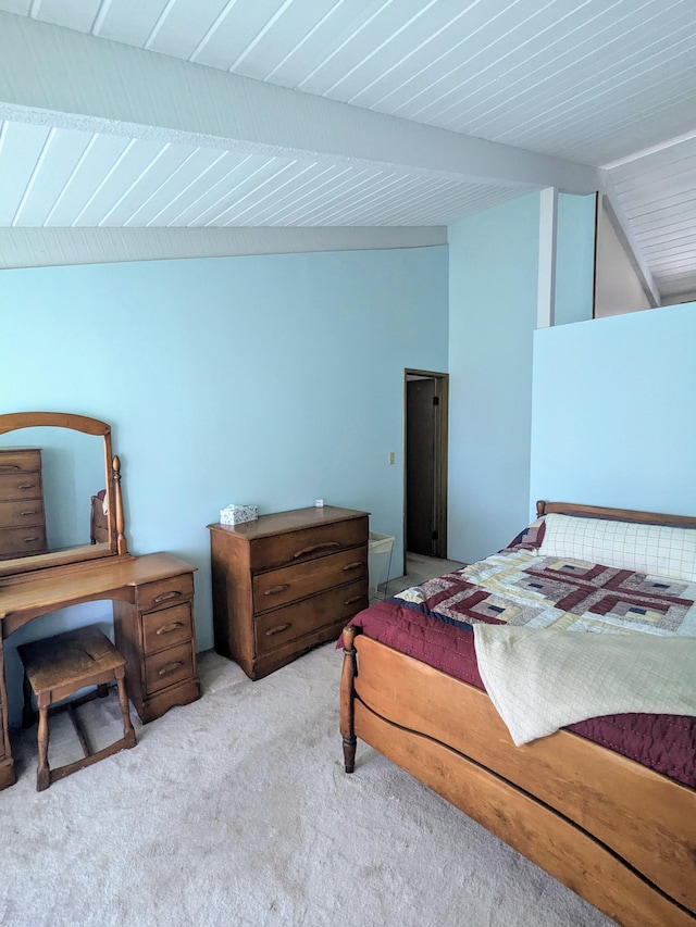 bedroom featuring light carpet and lofted ceiling with beams