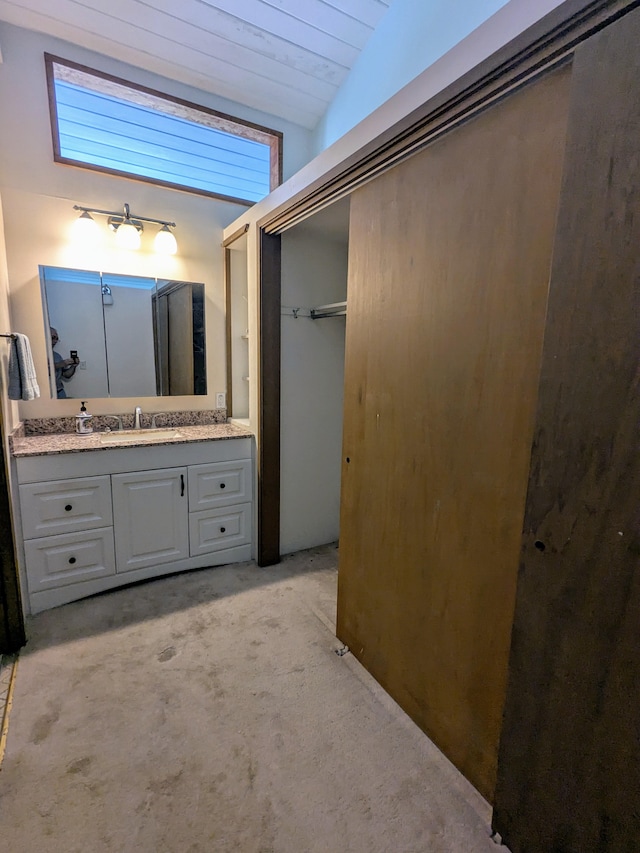 bathroom with vanity and lofted ceiling