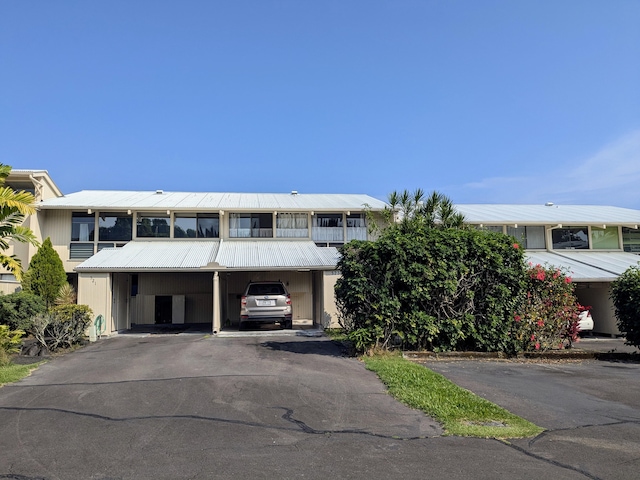 view of front of property with a carport and a balcony